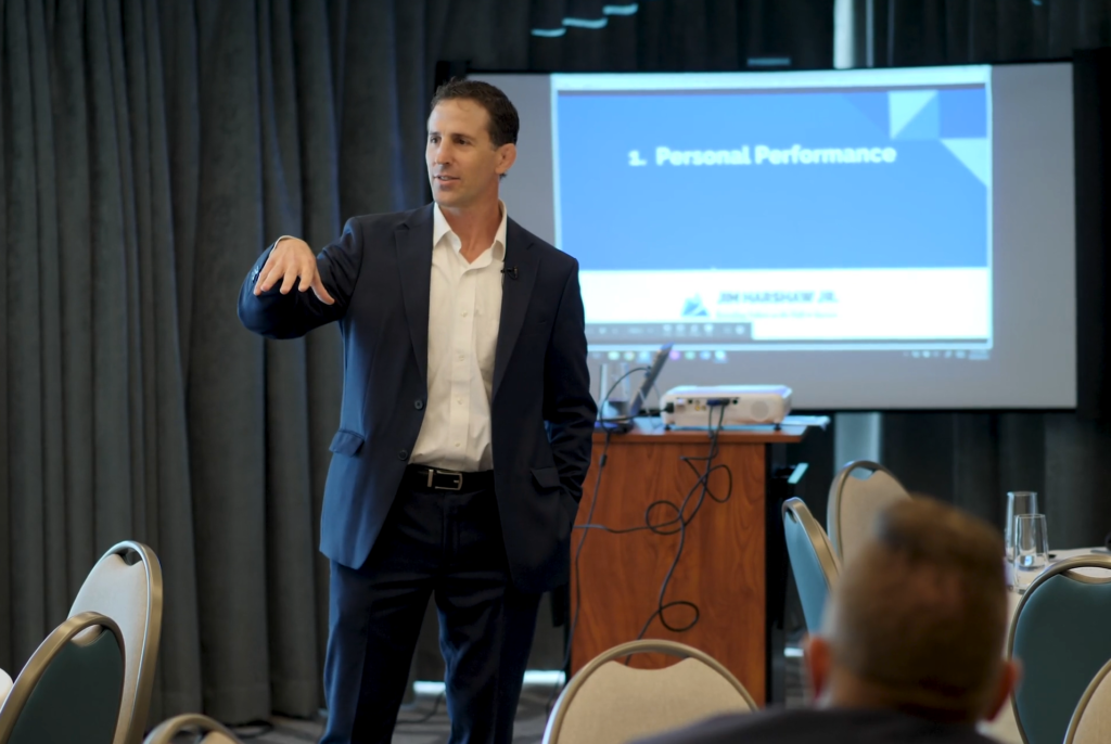 Jim Harshaw speaking in front of his clients (#289 Cheatsheet: 17 Tactics for Starting a Successful Side Hustle in 2021)