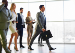 A group of people walking while being led with a man holding a suitcase (Success Through Failure episode 331: The Step-by-Step Method for Creating Your Leadership Philosophy: Find Clarity and Confidence in Your Toughest Leadership Decisions)
