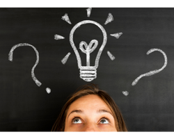 A lady looking up at a blackboard with a lightbulb doodled on it (Success Through Failure episode 385: The 8 Most Important Questions That Will Bring You Breakthrough, Clarity, and Peace of Mind in 2023)