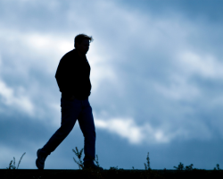 A silhouette of a walking man (Success for the Athleltic-Minded Man podcast episode #455 Lone Wolf Syndrome: The Hidden Costs of Male Independence (& What To Do About It))