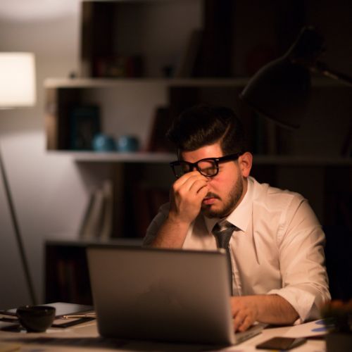 A working man looking stressed and burnout (Success for the Athletic-Minded Man podcast episode #477 The Myth of Busy: How to Be Productive Without Burning Out)